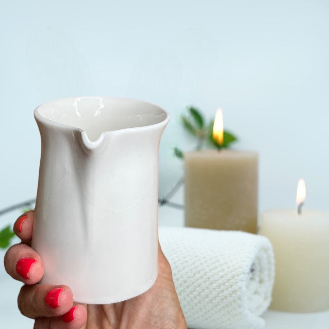 white ceramic massage candle with organic hemp seed oil and essential oils buddha and bubbles