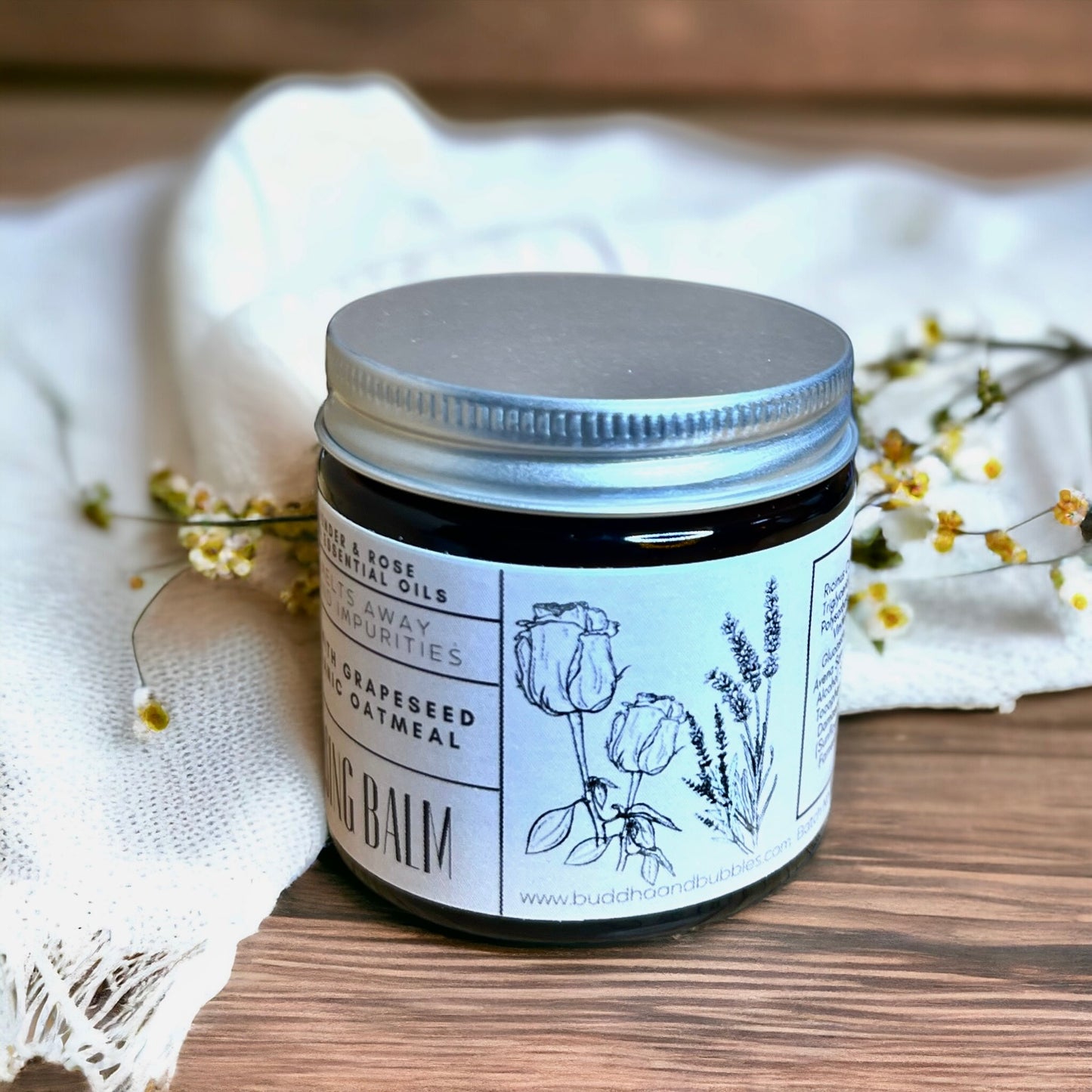 featuring a glass jar of cleansing balm on a wooden table made with oats and lavender and rose Damascena essential oils made by buddha and bubbles botanicals