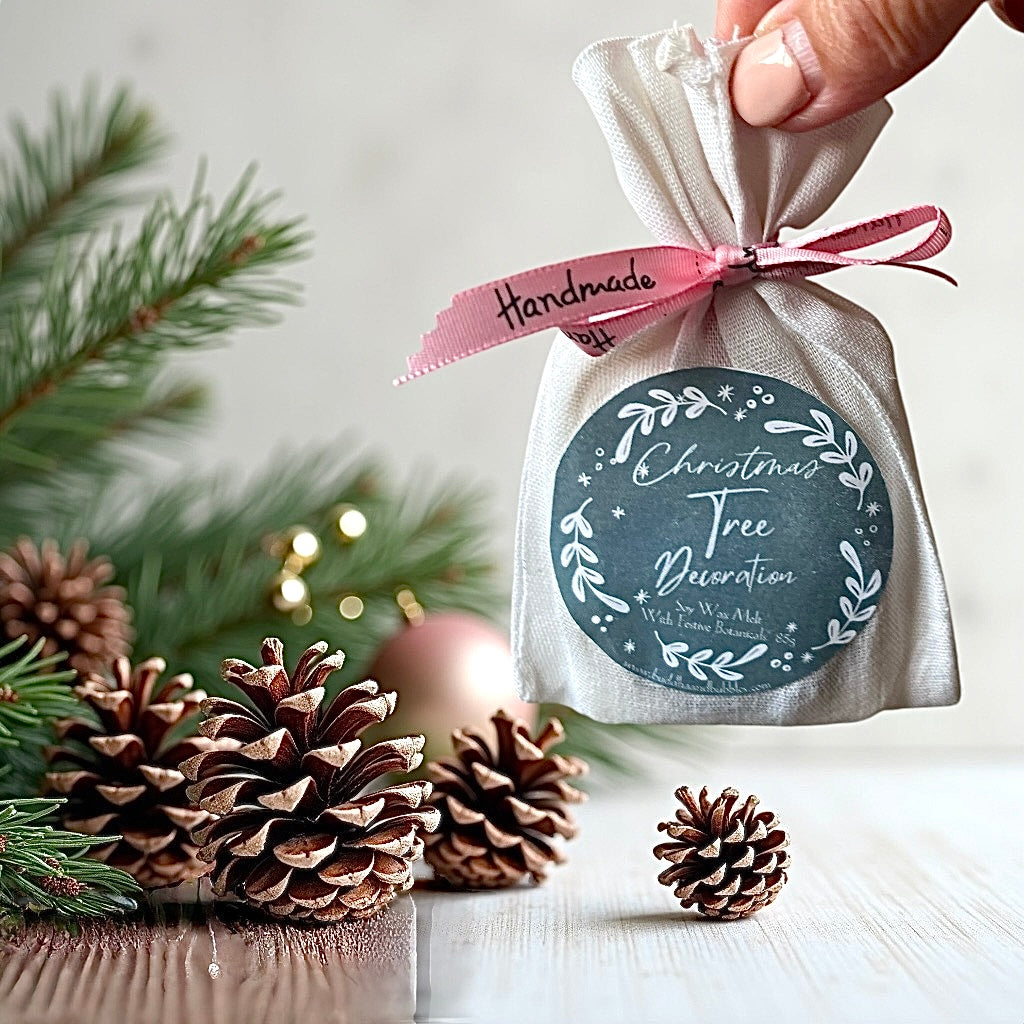 hand holding a Soy Wax Botanical Xmas Tree Decoration with reusable cotton bag drawer freshener made by buddha and bubbles botanicals
