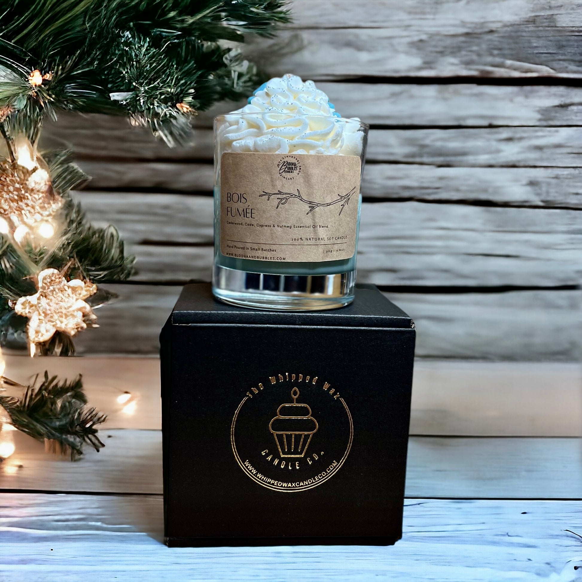 Candle with whipped cream on top in a decorative setting with gift box 