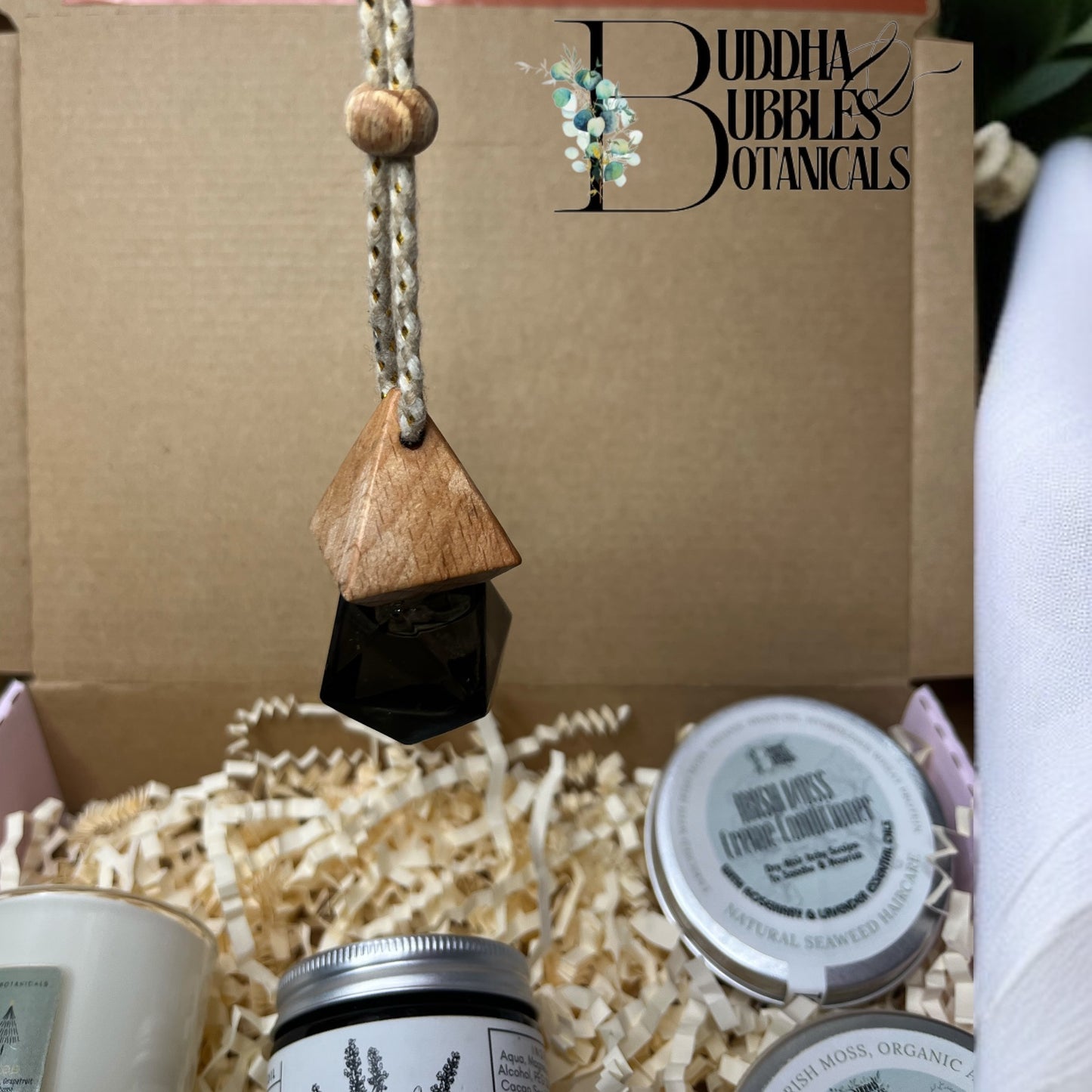 Buddha Bubbles Botanicals air freshener product with wooden hanging lid and beauty and haircare products with buddha and bubbles botanicals logo