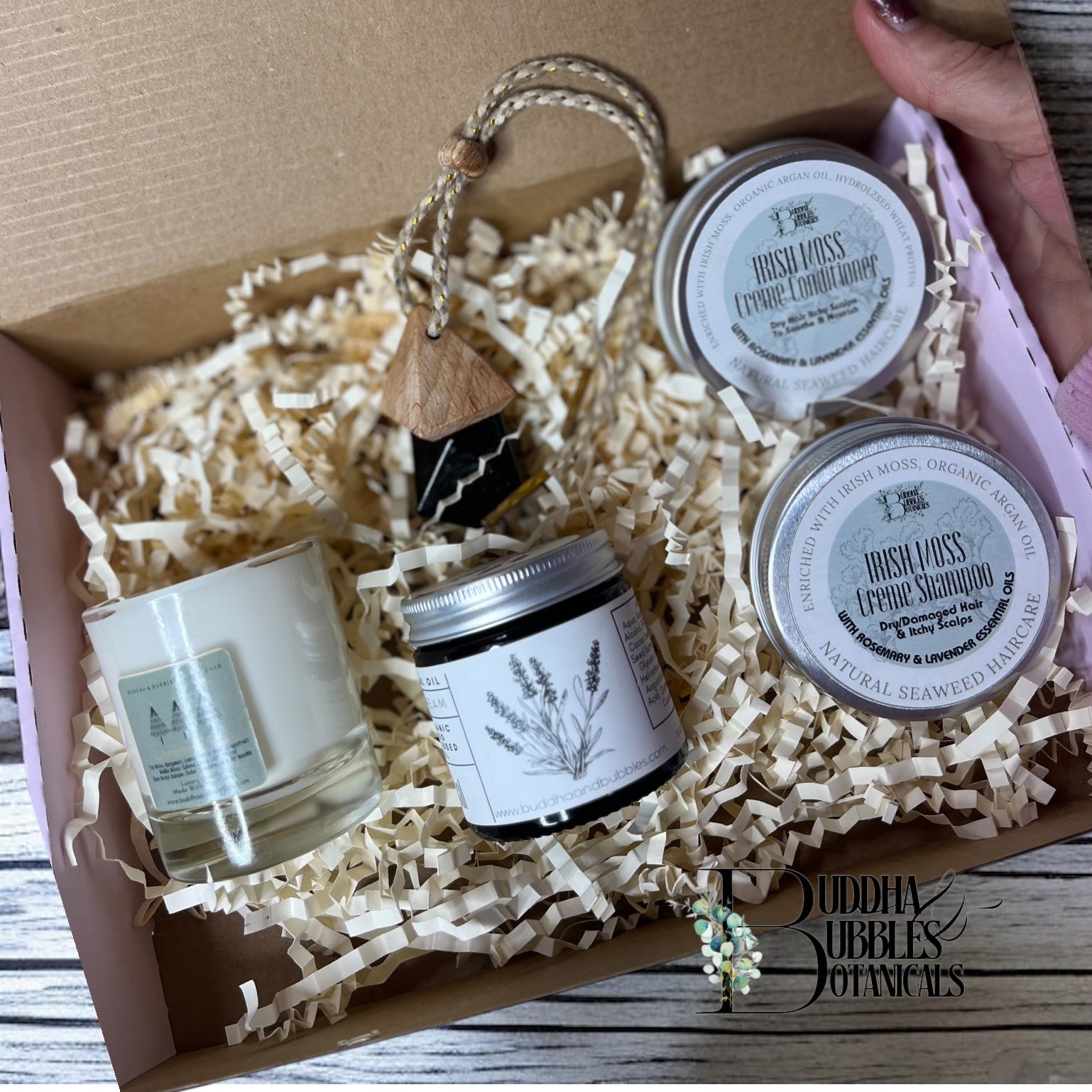 Xmas Gift set with candle seaweed shampoo and conditioner with magnesium cream  in a box labeled 'Buddha Bubbles Botanicals'.