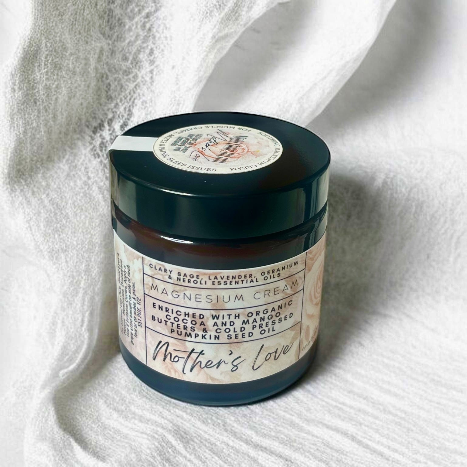 Jar of magnesium cream labeled 'Mother's Love' on a white fabric background