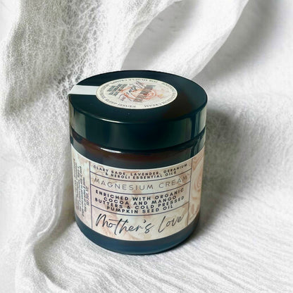 Jar of magnesium cream labeled 'Mother's Love' on a white fabric background