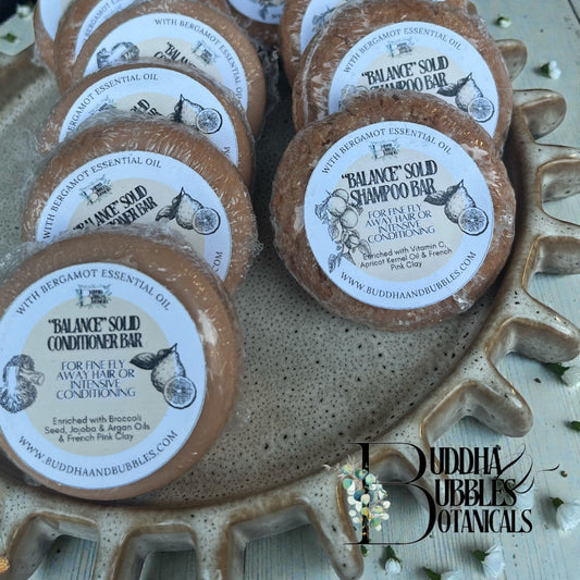 Buddha Bubbles Botanicals solid shampoo and conditioner bars on a decorative tray.