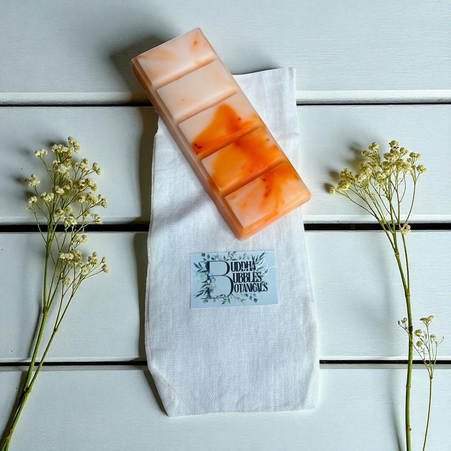 snap bar with a brand label on a white cloth, surrounded by small plants on a light wooden surface.