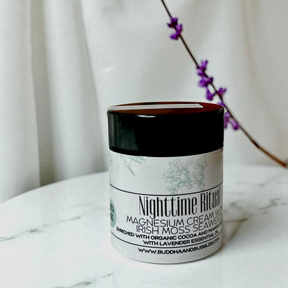 Tester size Jar of Nighttime Ritual magnesium cream on a marble surface with a white curtain background with lavender flower
