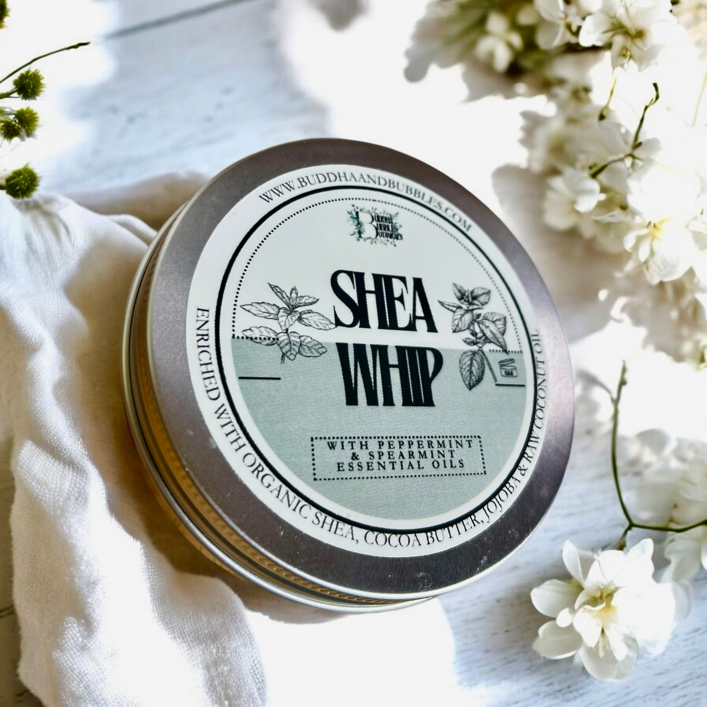 featuring  handmade shea whip body butter in aluminium tin with essential oils on a white background made by buddha and bubbles botanicals
