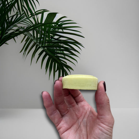 solid moisturising butter bar for the body held in a hand 