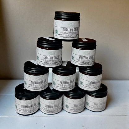 Pyramid of Nighttime Ritual Seaweed magnesium cream jars with black lids on a white surface.